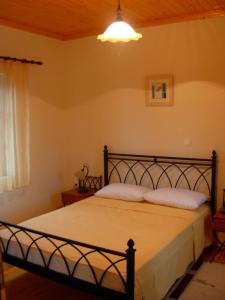 RepanídhionTerra Lemnia A的一间卧室配有一张带白色床单和一盏灯的床。