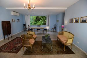 里约热内卢里约精品套房民宿的客厅配有椅子、桌子和窗户