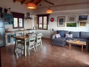 El Pinar del HierroCasa Rural Los Santillos的厨房以及带沙发和桌子的客厅。