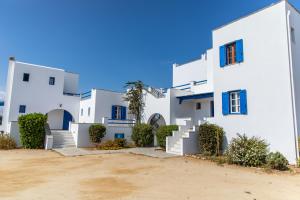 纳克索乔拉冲浪者天堂公寓的一排带蓝色窗户的白色房屋