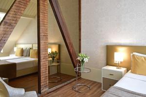 里斯本我的故事奥罗酒店的一间卧室配有两张床和镜子