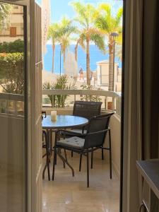 马贝拉Playa Fontanilla Apartments的海滩景阳台配有桌椅