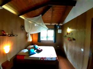PaopaoEco Lodge Village Temanoha的小房间,配有带雨伞的床