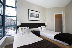 惠斯勒比尔阿尔派格洛夫公寓式酒店的带窗户的客房内的两张床