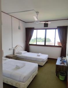 昆达桑纳瓦卢坤达萨山林小屋的酒店客房设有两张床和窗户。