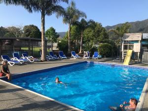 科罗曼德镇Coromandel TOP 10 Holiday Park的一群人在游泳池游泳