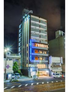 广岛起居室胶囊旅馆的一座高大的建筑,旁边是蓝色的灯