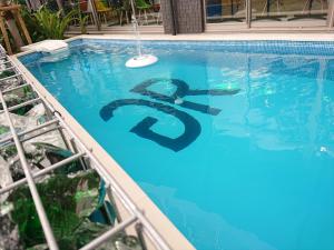 名户Green Rich Hotel Okinawa Nago (Artificial hot spring Futamata Yunohana)的水中带有1元标志的游泳池