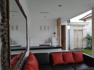BanjarVilla Santika的客厅配有带红色枕头的黑色沙发