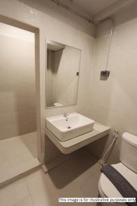 素叻Rajthani Hotel - SHA Certified的白色的浴室设有水槽和卫生间。