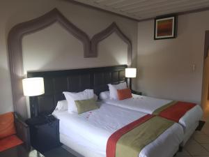 马拉喀什蓝色海洋春日酒店的一间卧室配有一张带两盏灯的大型白色床。
