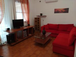 兹雷帕农FAMILY HOUSE NEAR THE BEACH DREPANO-NAFPLIo的客厅配有红色沙发和电视