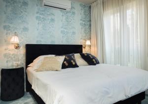斯普利特博班豪华套房酒店的卧室内的一张床铺,配有蓝色壁纸