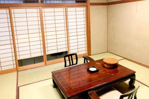 SagamichōTabist Ooriya Kochi的客房设有桌椅和窗户。