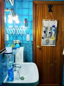 阿利坎特Alicante Room and gayfriendly的浴室配有水槽和蓝色瓷砖墙。