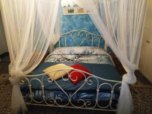 热那亚Delfino Blue的一间卧室配有一张带天蓬和窗帘的床