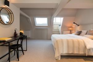 阿姆斯特丹Empire suites roof terras的一间卧室配有一张床、一张书桌和一面镜子