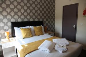 Minworth明维斯酒店的一间卧室配有一张大床和毛巾