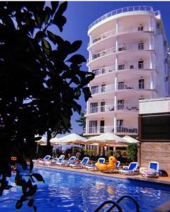 科布列季Kobuleti Pearl Of Sea Hotel & Spa的一座带椅子的游泳池以及一座大型建筑