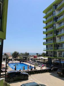 北马马亚-讷沃达里Apartament Sunshine - Spa n Pool Beach resort, vedere la mare, 3 camere的大楼旁停车场的游泳池