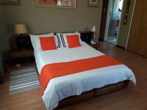鲁德普特At The View B&B的一间卧室配有一张带橙色和白色枕头的大床