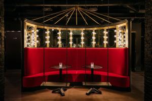 伦敦Ruby Lucy Hotel London的室内的红色长凳和两张桌子