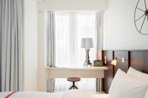 伦敦Ruby Lucy Hotel London的一间卧室配有书桌、床和窗户。