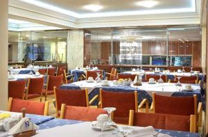 拉米亚萨马拉斯酒店的一间配备有桌椅及蓝桌布的用餐室