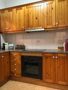 莫雷拉Casa San Nicolás的厨房配有木制橱柜和黑色洗碗机。