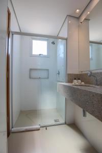 蒙蒂斯克拉鲁斯Hotel Amsterdam Montes Claros的一个带水槽的玻璃淋浴间