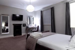 莱斯特城市客房酒店的一间卧室配有两张床、一张桌子和一面镜子