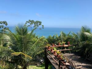 特林达德Espaço Indio Tupi的阳台种有棕榈树,背景是大海