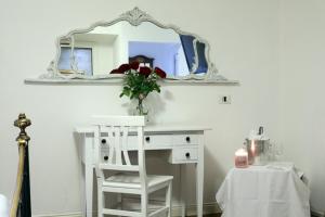 波梅齐亚阿尔卡斯特罗酒店的一张带镜子的白色书桌和一张白色椅子