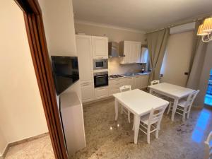 福贾B&B San Michele Foggia的厨房配有白色橱柜和桌椅