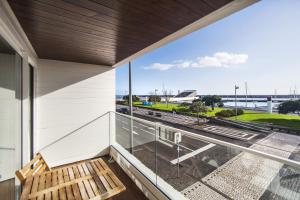 蓬塔德尔加达Hotel Gaivota Azores的阳台设有木凳,享有街道的景色。