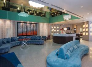 克雷塔罗克雷塔罗智选假日套房酒店的一个带蓝色沙发的大型大堂和一间酒吧