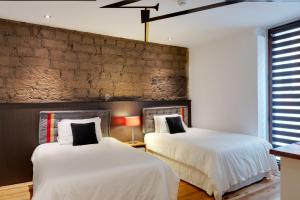 基多卡萨卡德尼亚酒店的砖墙客房的两张床