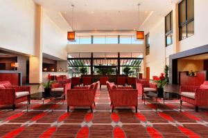 安大略Ontario Airport Hotel & Conference Center的大堂,设有红色的椅子和桌子