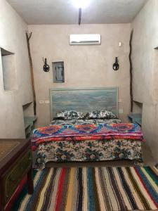 杜兹Grand Sud, la maison de sable的一间卧室配有一张带五颜六色棉被的床