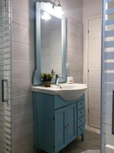卡西奥皮Alekas Harbour House的浴室设有蓝色水槽和镜子