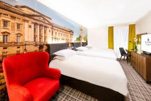 伦敦千禧国际伦敦格洛斯特酒店的酒店客房,设有三张床和红色椅子
