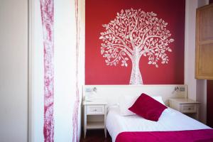 GrizzanaHotel Il Crinale的卧室设有红墙和树壁画