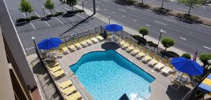 大洋城海鹰汽车旅馆的享有带椅子和遮阳伞的游泳池的上方景色