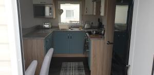 博特夫加滕Bonnie Gorm的一间小厨房,内配蓝色橱柜和水槽
