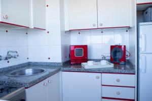 巴哈马尔Sunset Dream Bajamar GREAT VIEWS的一个带水槽和红色用具的小厨房