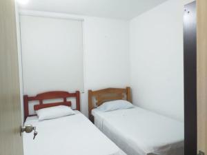 蒙特里亚Apartamento con piscina的配有白色床单的客房内的两张床