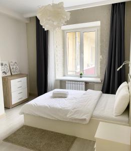 莫斯科Aparthotel Lind的卧室配有白色的床和窗户。