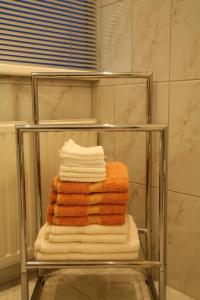 Zuid-Beijerland科伦代克住宿加早餐旅馆的浴室毛巾架上的一堆毛巾