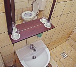 巴亚马雷Cazare Karmina的浴室设有水槽和一个带玻璃杯的架子。