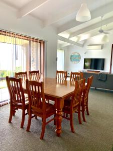 金斯科特Beachside House的一间带木桌和椅子的用餐室